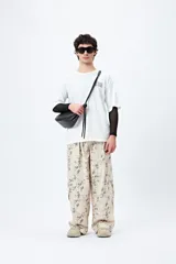 Remera blanca de corte amplio con mangas cortas y estampado con la frase "Unlearn" en el frente y gráfico en la espalda.