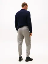 Pantalón de jogging gris melange, confeccionado en mezcla de algodón y poliéster, con corte regular y pierna cónica. Presenta cintura con cordón, bolsillos laterales y un bolsillo trasero de ojal.