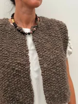 Collar de cuentas de piedras naturales en tonos tierra, con detalles de tubos dorados en los laterales.