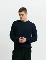 Sweater de punto inglés con escote redondo y mangas largas. Presenta cuello y puños terminados en punto canalé.