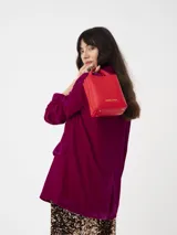 Blazer de terciopelo rojo, corte cuadrado y moderno, con botones dorados y forro interior.