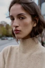 Jersey de punto liso con cuello subido y manga larga, de corte holgado y diseño minimalista.