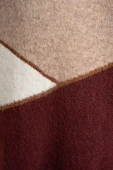 Sweater de tejido de punto con diseño de bloques de color en tonos beige, blanco roto y bordó. Presenta cuello redondo y mangas largas.