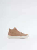 Botín de cuero color nude, con caña alta, cordones y suela blanca.