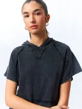 Chaleco negro lavado de algodón con capucha y gran bolsillo central. De corte oversized, holgado, suave y cómodo.