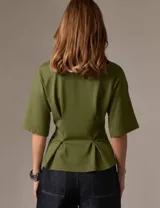 Remera de diseño estructurado color verde militar, con mangas amplias y silueta entallada mediante pinzas frontales que definen la cintura.