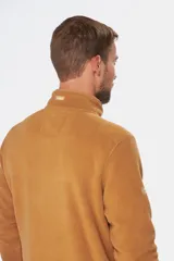 Buzo térmico de polar en color azul marino, con cuello alto y cierre frontal parcial mediante broches. Presenta bolsillos laterales con cierre y un bolsillo adicional con cierre en la manga izquierda.