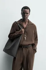 Camisa de manga larga color marrón oscuro, con cuello solapa y abertura frontal, confeccionada en tejido fluido con mezcla de modal. Presenta un calce relajado y aberturas laterales en el bajo.