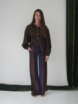 Pantalón de paño combinado con tira de cuero color marrón.