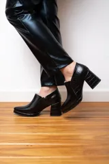 Botines negros de cuero con plataforma y taco cuadrado con textura de reptil.