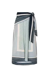 Pollera midi de algodón con silueta en línea A, cintura alta con cruce frontal y lazo lateral. Presenta un estampado de rayas en diferentes anchos y direcciones, con dobladillo recto y pespuntes.