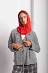 Saco de tejido de punto color gris, de corte holgado, con cuello redondo y cierre frontal con lazos.