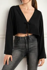 Blusa corta negra con escote en V y mangas largas acampanadas.