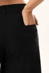 Pantalón de tiro medio con corte súper acampanado, confeccionado en gabardina con spandex. Presenta bolsillos delanteros y traseros, con cierre frontal de cremallera y botón.