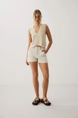 Short de denim azul de tiro medio, con bolsillos delanteros aplicados y dobladillo en las piernas.