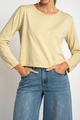 Remera color amarillo pastel de algodón peinado, corte recto y mangas largas.