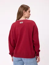 Sweater negro de corte regular con cuello redondo y puños y dobladillo acanalados con detalles de rayas grises. Presenta estampados blancos en el frente con el texto "Rusty Club" y logos de la marca.