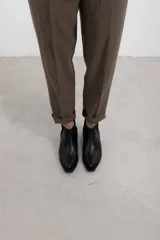 Botineta de cuero negro con textura sutil, con elásticos laterales y taco cuadrado bajo.
