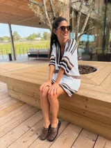 Vestido corto tejido en hilo de algodón color blanco con rayas horizontales marrones y negras, escote en V y mangas cortas.