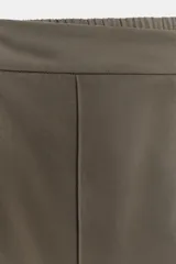 Pantalón de tiro alto con pernera recta, cintura elástica en la parte posterior y nervio marcado en el frente. Cuenta con cierre frontal de botón y ganchos, bolsillos delanteros y bolsillos de plastrón en la parte trasera.