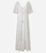 Vestido largo evasé de crepé blanco con textura y volados. Tiene escote corazón, elástico en la cintura, lazo con cordón y borla en las puntas, y mangas cortas.