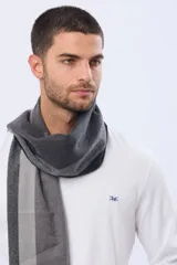 Bufanda de tejido suave con diseño de cuadros en tonos marrones y líneas finas oscuras, terminada con flecos en los extremos.