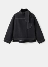 Blusa de mezclilla negra con costuras en contraste, cuello alto y solapa trasera.
