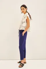 Pantalon estilo babucha color negro, con cintura elastizada y cordón de ajuste, bolsillos diagonales frontales y puños en los tobillos.