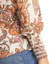 Blusa de gasa con estampado de arabescos en tonos tierra sobre base beige. Presenta escote en V con detalle fruncido y mangas 3/4 con puños anchos en punto smock.