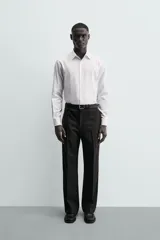 Camisa de corte slim fit confeccionada en tejido de algodón. Presenta cuello italiano, manga larga con puños abotonados y cierre frontal mediante botonadura clásica.