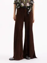 Pantalon de tiro alto y silueta wide leg confeccionado en cuero caprino con acabado de gamuza color chocolate. Presenta recortes verticales que estructuran la prenda y tajos laterales en el ruedo.