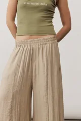 Pantalón ancho color marrón con cintura elástica y bolsillos laterales.