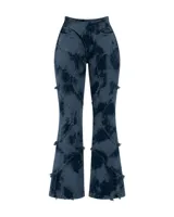 Pantalón de denim elastizado con lavado efecto tie-dye en tonos azul petróleo y negro. Presenta un diseño de tiro alto con recortes irregulares, costuras decorativas con terminaciones desflecadas y corte ligeramente acampanado.