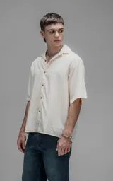 Camisa de manga corta con cuello cubano y cierre frontal de botones, de corte oversize y diseño minimalista.