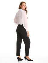 Pantalón de corte recto confeccionado en crepe, con cintura alta y detalle de botones metálicos dorados decorativos en los laterales. Presenta una silueta estructurada y elegante.