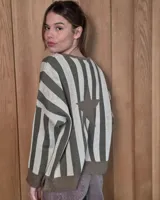 Buzo de tejido de punto con diseño de rayas verticales en tonos verde oliva y beige, presenta una estrella grande estampada en la espalda, corte holgado y mangas largas.