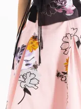 Pollera midi evasé tableada de color rosado, confeccionada en algodón con un estampado de flores y abejas, enriquecido con bordado de mostacillas.