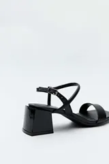 Sandalias Daniel Cassin modelo Nina, de color negro, con tira delantera ancha, puntera cuadrada, taco bajo bloque y tiras finas cruzadas en el talón con cierre de hebilla ajustable.