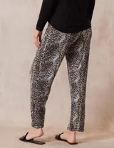 Conjunto de pijama marca René Rofé, compuesto por remera negra de manga larga con bolsillo en el pecho y pantalón largo con estampado animal print, cintura elastizada y lazo de ajuste.