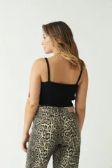 Top tejido de punto color beige, con escote corazón y breteles finos. Presenta una textura acanalada y un corte corto al cuerpo.