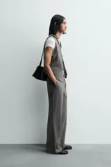 Chaleco de traje regular fit confeccionado en tejido con lana, con cuello en pico, cierre frontal de botones y bolsillos de vivo en la cintura. Presenta forro interior con diseño de rayas.