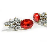 Par de aros dorados con apliques de piedras rojas y transparentes.