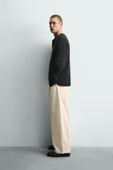 Jersey relaxed fit de punto acanalado color marrón oscuro, con cuello redondo tipo panadera y cierre frontal de tres botones. Tiene manga larga y efecto lavado.