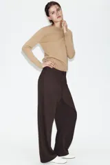 Pantalón de tiro alto con diseño tipo balloon, cintura con trabillas, bolsillos laterales y cierre frontal con cremallera y botón.