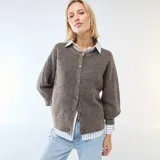 Cárdigan de punto grueso en color marrón, con cuello redondo, cierre frontal de botones y mangas largas con puños ajustados.