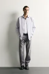 Jeans regular fit confeccionados en denim de algodón celeste con efecto lavado, de cinco bolsillos y cierre frontal con cremallera y botón.
