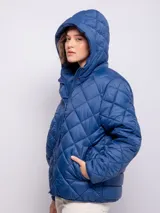 Campera capitoneada color ladrillo con capucha, cierre frontal con botones a presión y cremallera, bolsillos laterales y puños elastizados.