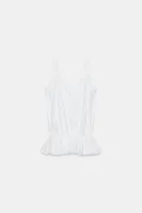 Top de tirantes con escote en pico, detalle de volantes en los hombros y bajo con volado fruncido que aporta volumen.