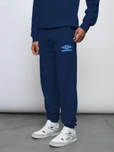 Pantalón jogger azul marino de felpa sin frisa, con logo Umbro bordado en azul claro en el muslo izquierdo y puños elásticos en los tobillos.