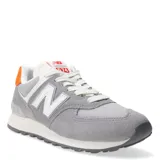Championes urbanos New Balance modelo 574, color gris con detalles en blanco y naranja en el talón. Confeccionados en gamuza y malla, cuentan con el logo N característico en los laterales y entresuela con tecnología ENCAP para mayor amortiguación.